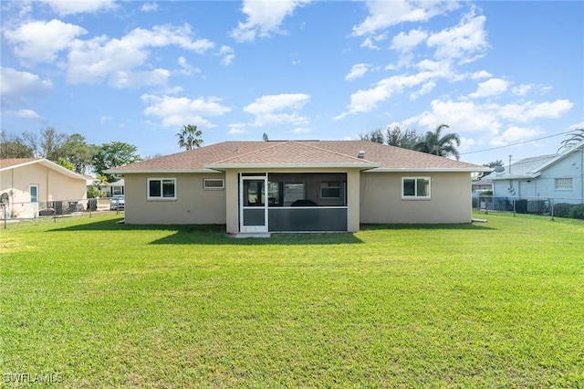 back of house with a sunroom and a lawn