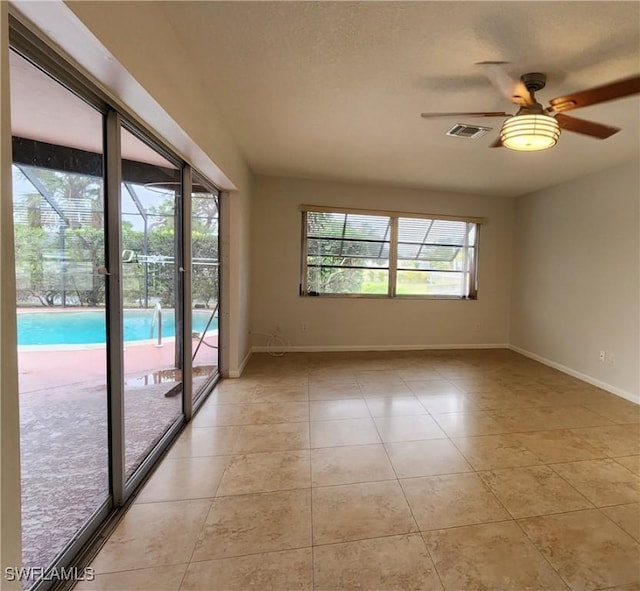 tiled spare room with ceiling fan