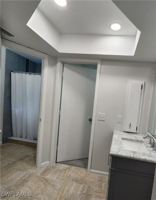 bathroom featuring vanity and a raised ceiling