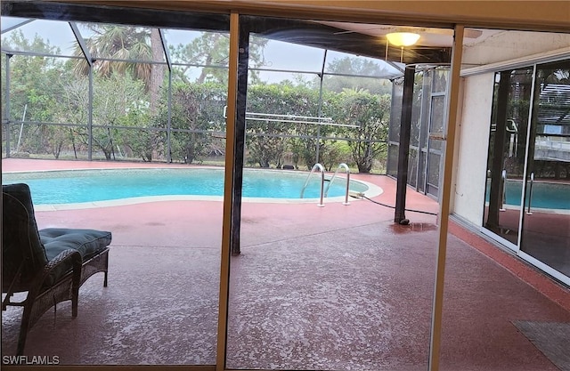 view of swimming pool featuring a patio area and glass enclosure