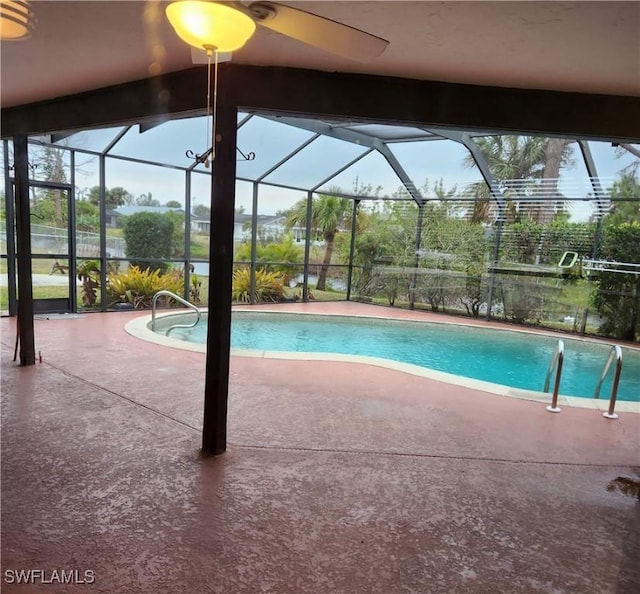 view of swimming pool featuring a lanai and a patio