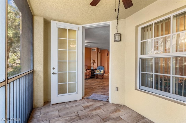 unfurnished sunroom featuring ceiling fan