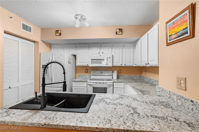 kitchen with sink, white cabinets, white appliances, light stone counters, and a textured ceiling