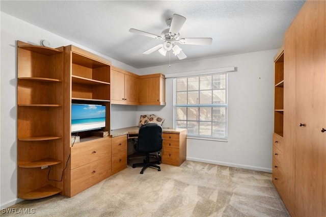 office space featuring ceiling fan, light colored carpet, and a textured ceiling