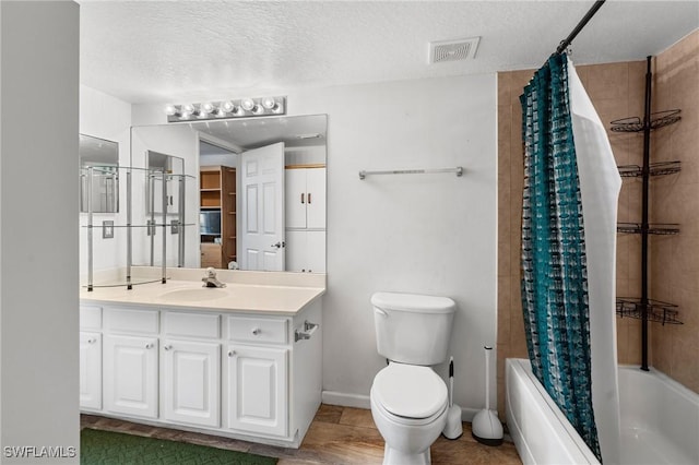 full bathroom featuring vanity, toilet, a textured ceiling, and shower / bath combo