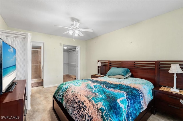 carpeted bedroom featuring a spacious closet, connected bathroom, ceiling fan, and a closet