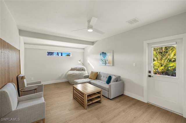 living room featuring ceiling fan, lofted ceiling with beams, and light wood-type flooring