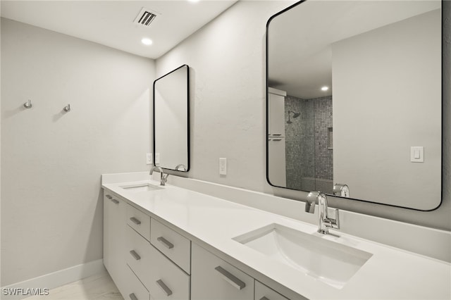 bathroom with vanity and tiled shower