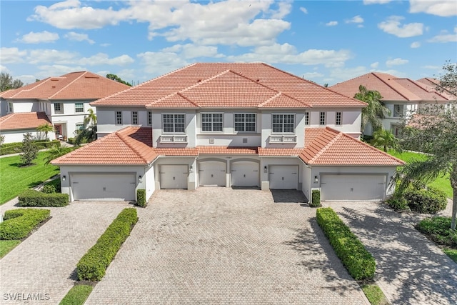 mediterranean / spanish-style home with a tiled roof, driveway, and stucco siding