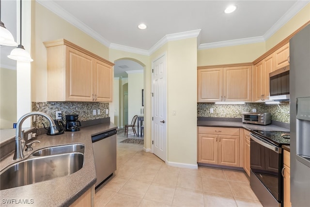 kitchen with light brown cabinets, appliances with stainless steel finishes, dark countertops, and a sink