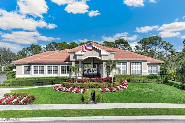 view of front of house featuring a front yard, a tile roof, and stucco siding