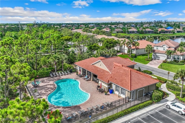 community pool featuring a residential view, a patio area, and fence
