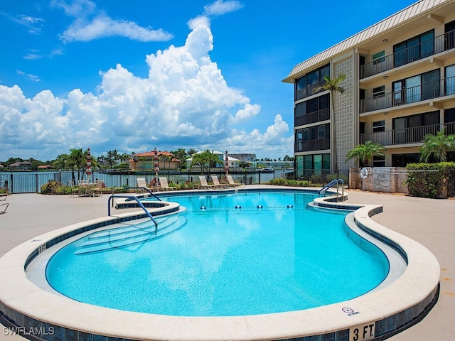 view of pool featuring a patio and a water view