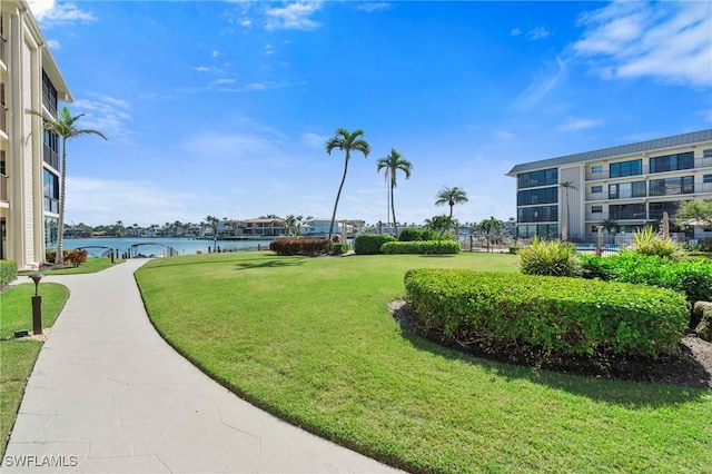 surrounding community with a lawn and a water view