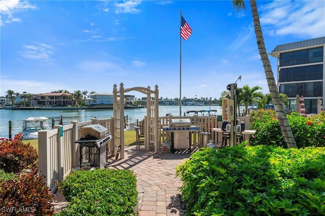 view of patio with a grill and a water view