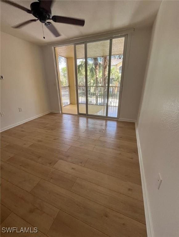 unfurnished room featuring light hardwood / wood-style flooring, expansive windows, and ceiling fan