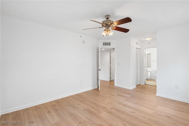 empty room featuring a ceiling fan, baseboards, visible vents, and light wood-type flooring