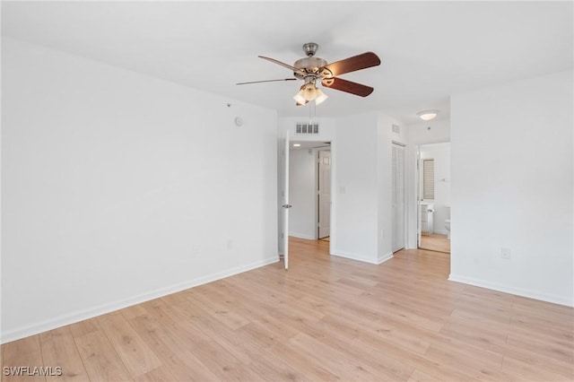 spare room with ceiling fan, baseboards, visible vents, and light wood-type flooring