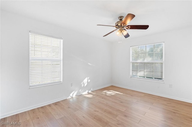 empty room featuring light wood finished floors, ceiling fan, and baseboards