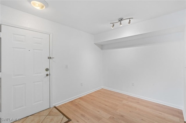 spare room featuring light wood-type flooring and baseboards