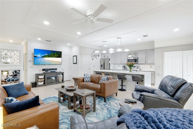 tiled living room featuring ceiling fan, a raised ceiling, and sink