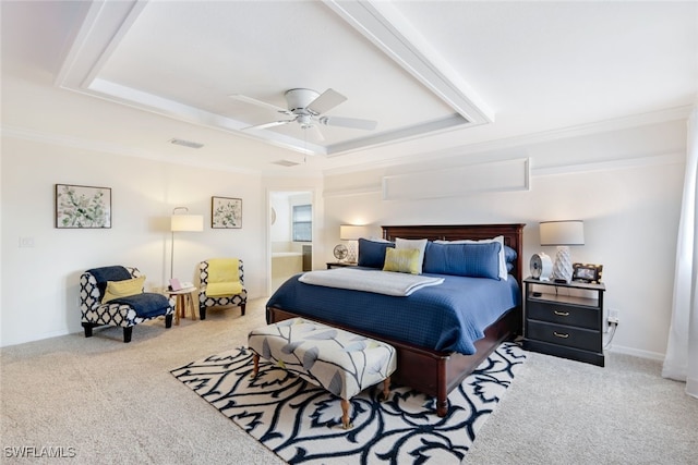 carpeted bedroom featuring ornamental molding, ensuite bath, ceiling fan, and a tray ceiling