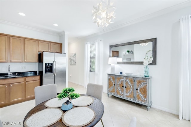 dining space featuring sink, crown molding, a notable chandelier, and light tile patterned flooring