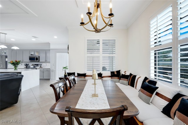 tiled dining space featuring ornamental molding and a notable chandelier