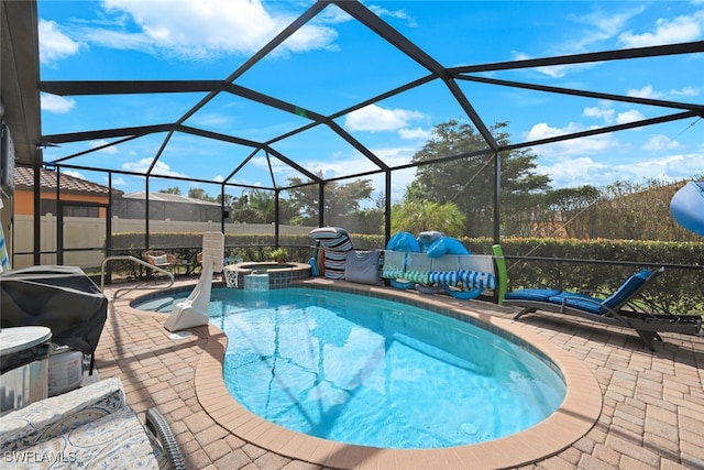 view of pool featuring an in ground hot tub, a patio, and glass enclosure