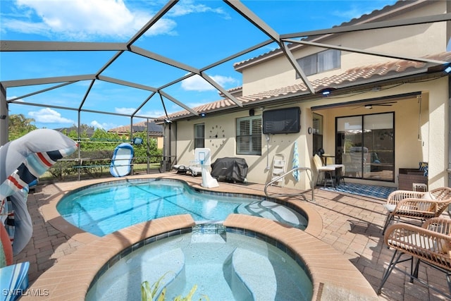 view of swimming pool featuring an in ground hot tub, ceiling fan, a patio, and glass enclosure