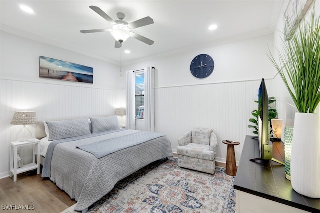 bedroom with ceiling fan, ornamental molding, and wood-type flooring