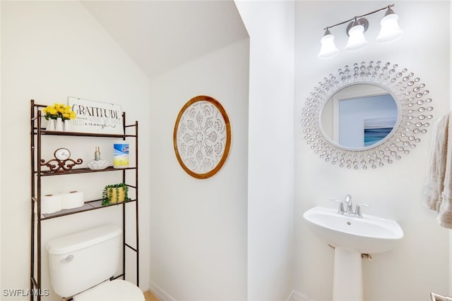 bathroom featuring lofted ceiling, sink, and toilet