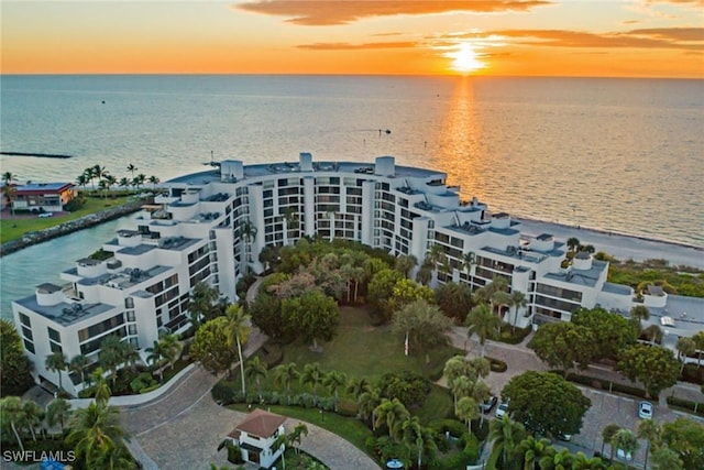 aerial view at dusk featuring a water view