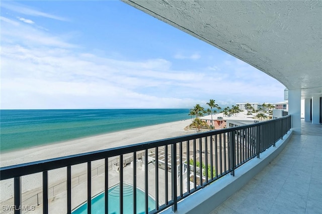 balcony featuring a water view and a beach view