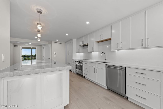 kitchen featuring pendant lighting, light hardwood / wood-style floors, white cabinets, and appliances with stainless steel finishes