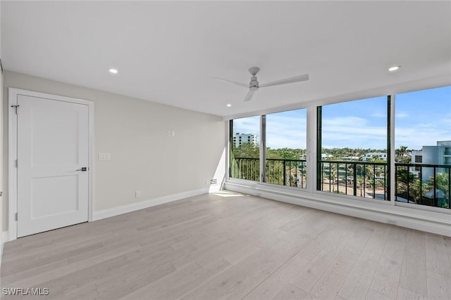 spare room with ceiling fan and light wood-type flooring