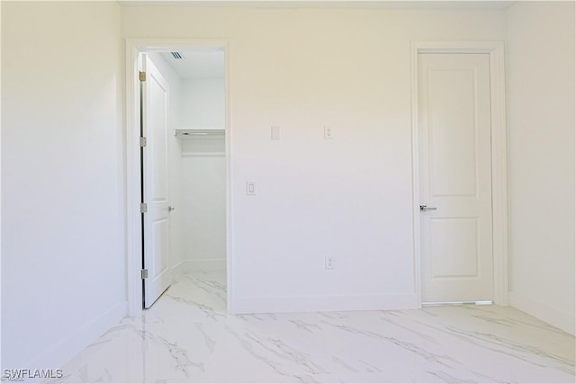 unfurnished bedroom featuring a spacious closet and a closet