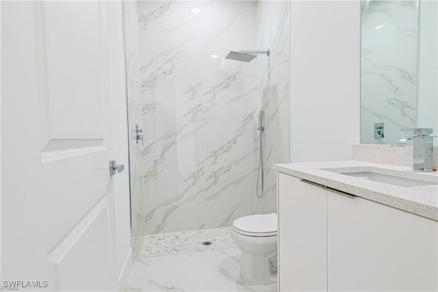 bathroom with vanity, toilet, and a tile shower