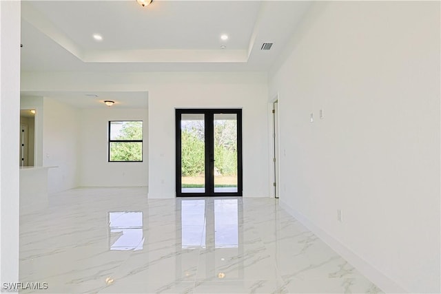 unfurnished room featuring french doors and a tray ceiling