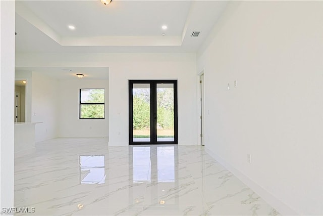 spare room with a raised ceiling and french doors