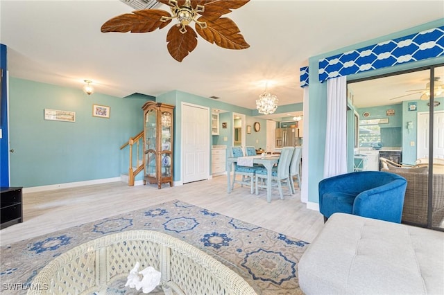 living room with hardwood / wood-style flooring and ceiling fan with notable chandelier