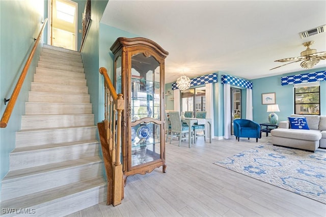 stairs featuring a healthy amount of sunlight, hardwood / wood-style floors, and ceiling fan