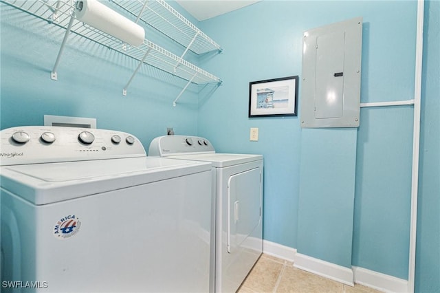 clothes washing area with light tile patterned floors, electric panel, and washing machine and dryer