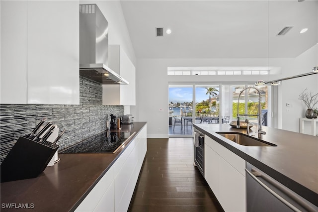 kitchen featuring dishwasher, sink, white cabinets, black electric stovetop, and wall chimney exhaust hood