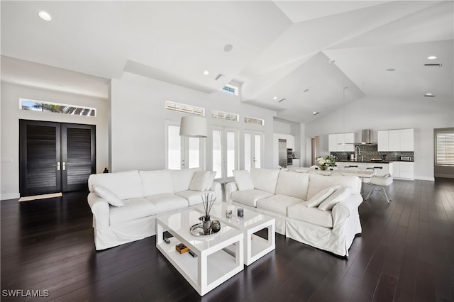 living room featuring dark hardwood / wood-style floors, high vaulted ceiling, and french doors