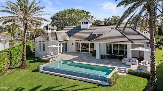 back of house featuring an outdoor living space, a patio, and a yard