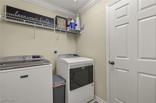 laundry area with washing machine and clothes dryer and ornamental molding