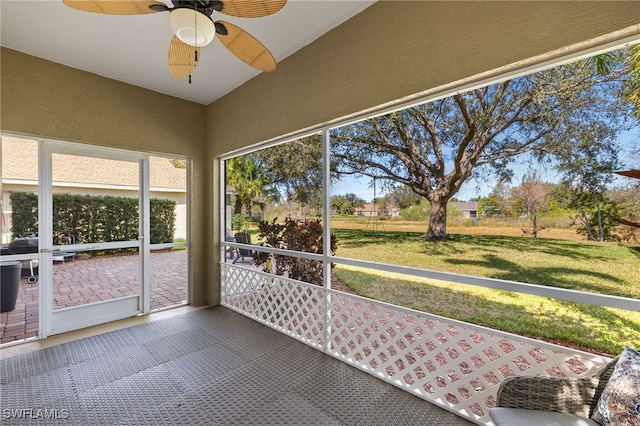 unfurnished sunroom featuring ceiling fan