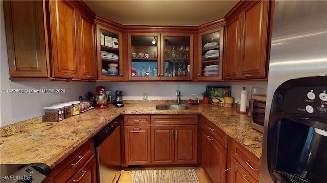 kitchen featuring light stone counters, appliances with stainless steel finishes, and sink