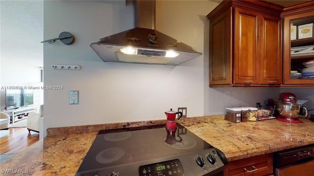 kitchen featuring range hood, black dishwasher, stainless steel range, light hardwood / wood-style floors, and light stone countertops